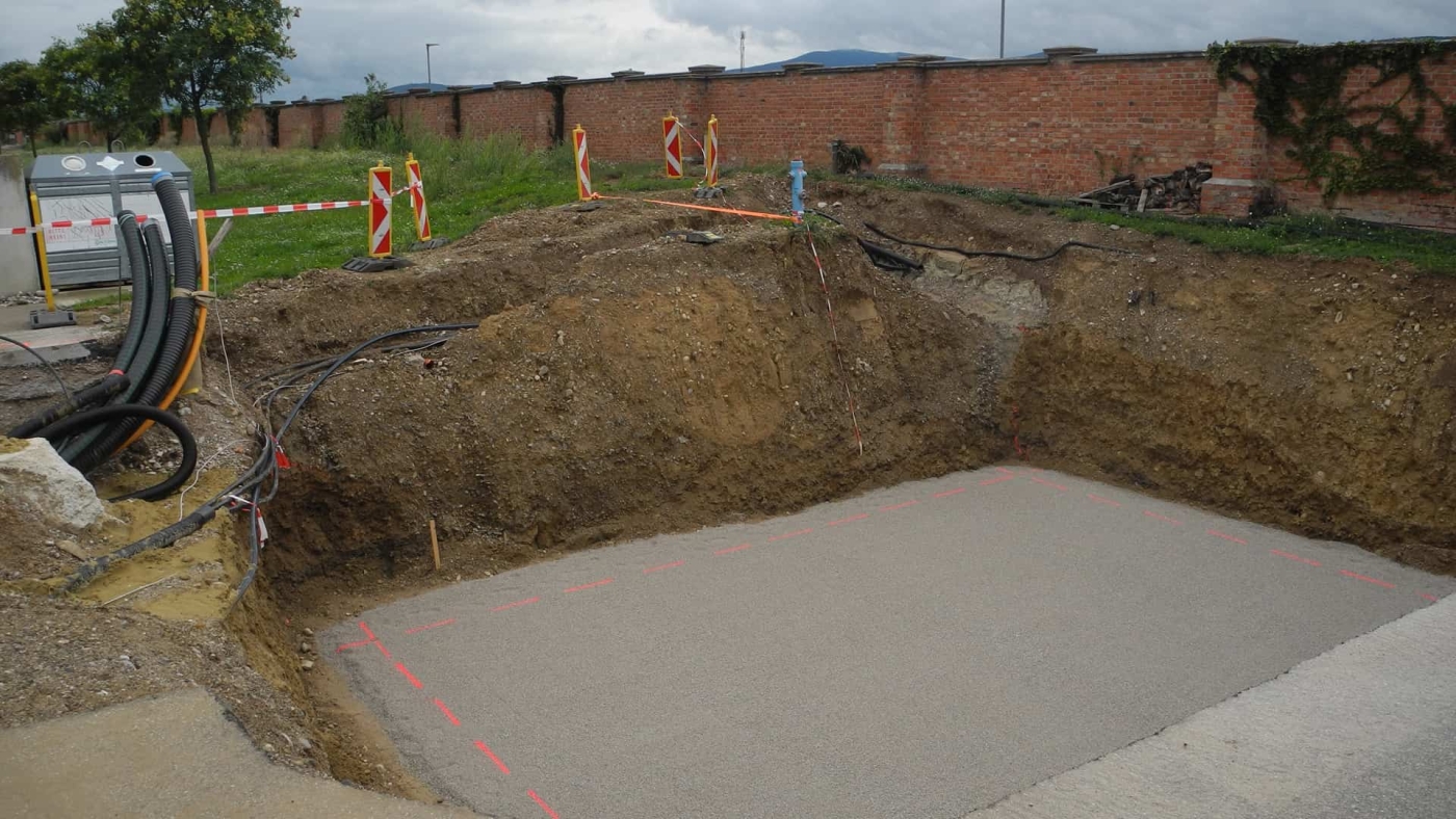 Ausgehobene Baugrube für die Installation eines SISTEMS GROUND CUBE mit Fundament und Versorgungsleitungen.